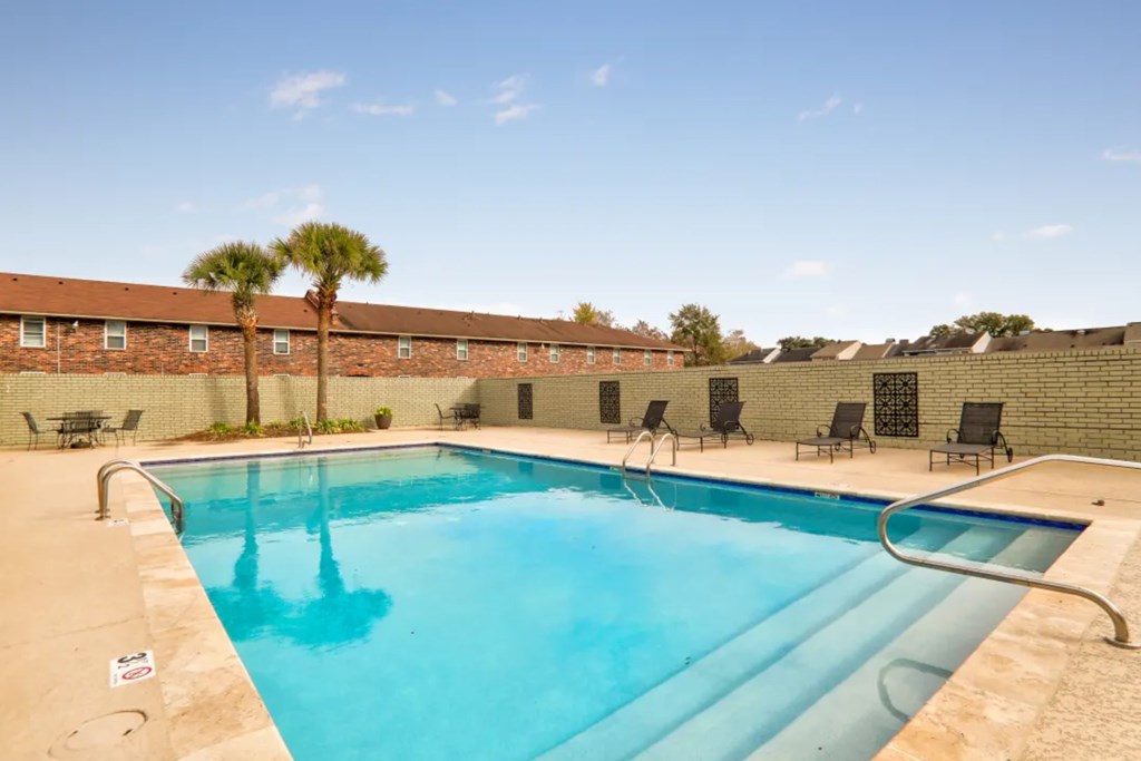 A swimming pool with a metal ladder and a metal railing.
